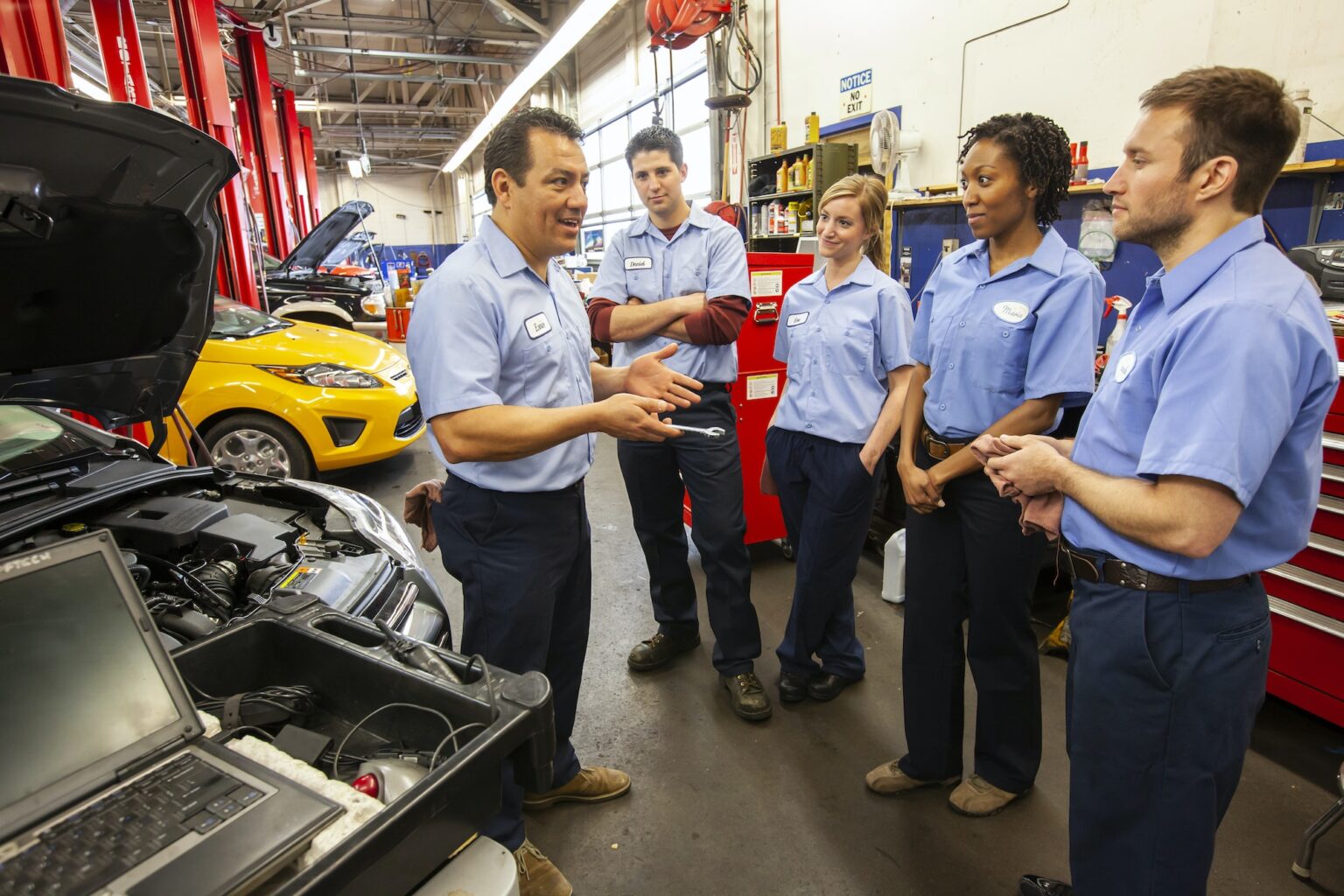 Men and women of diverse ethnic backgrounds, a team of mechanics in an auto repair shop